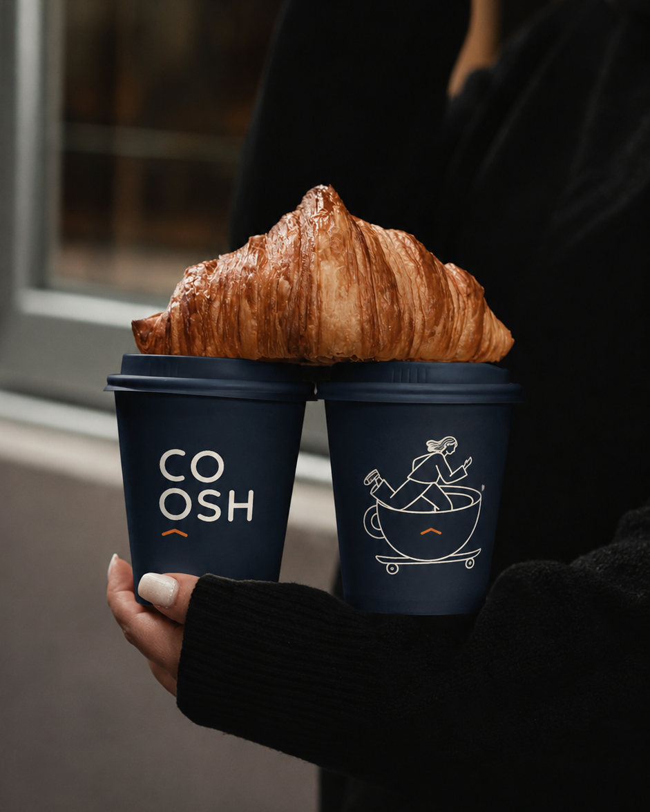 كوبا قهوة COOSH الكحليان في اليد، عليهما الشعار والشخصية، وفوقهما Croissant