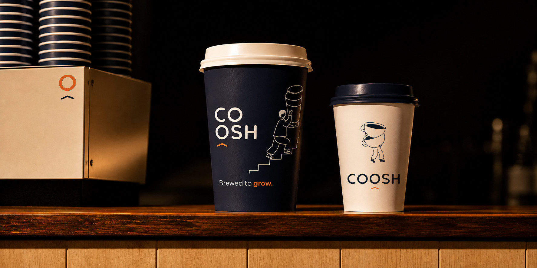 كوبا قهوة COOSH في المقهى: الكحلي بالشخصية تصعد الدرج والشعار النصي Brewed to grow، والأبيض بالشعار