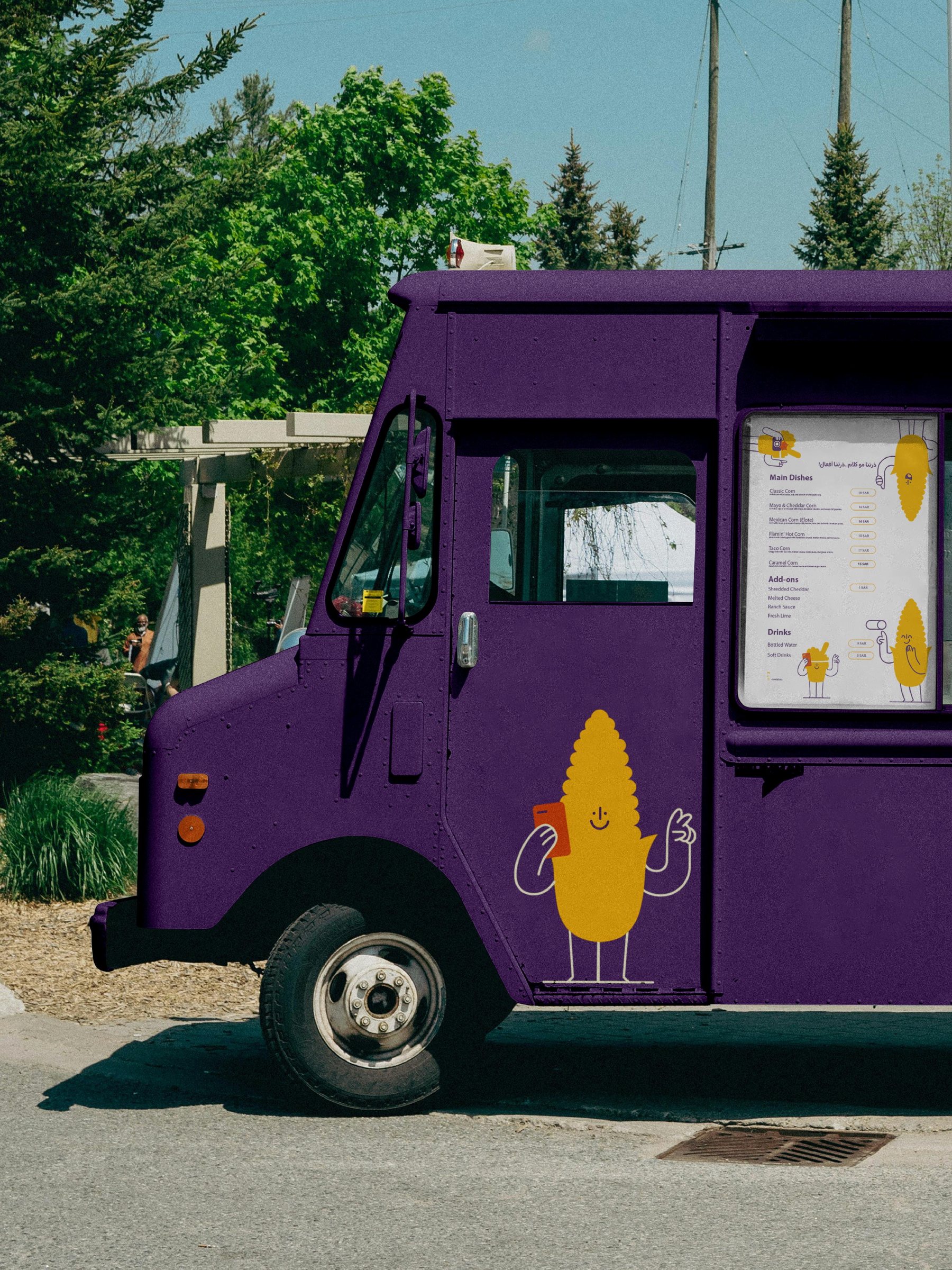 عربة CornLab البنفسجية بشخصية عرنوس الذرة على جانبها