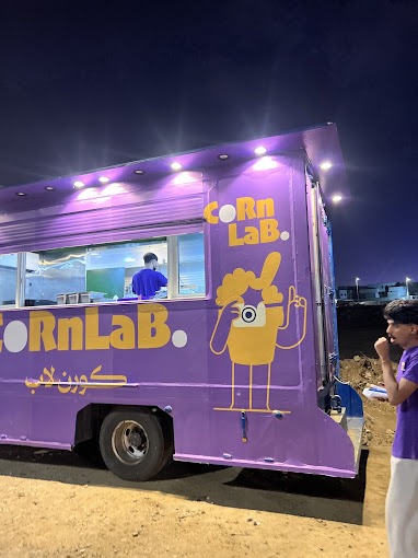 جانب عربة CornLab البنفسجي بشخصية الكوب والشعار